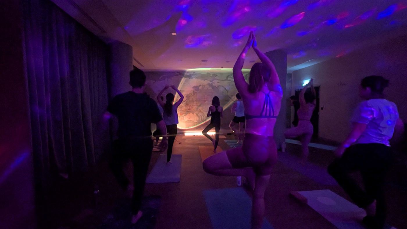 Studio Atlantis : cours de yoga dans une salle sombre aux lumières violettes